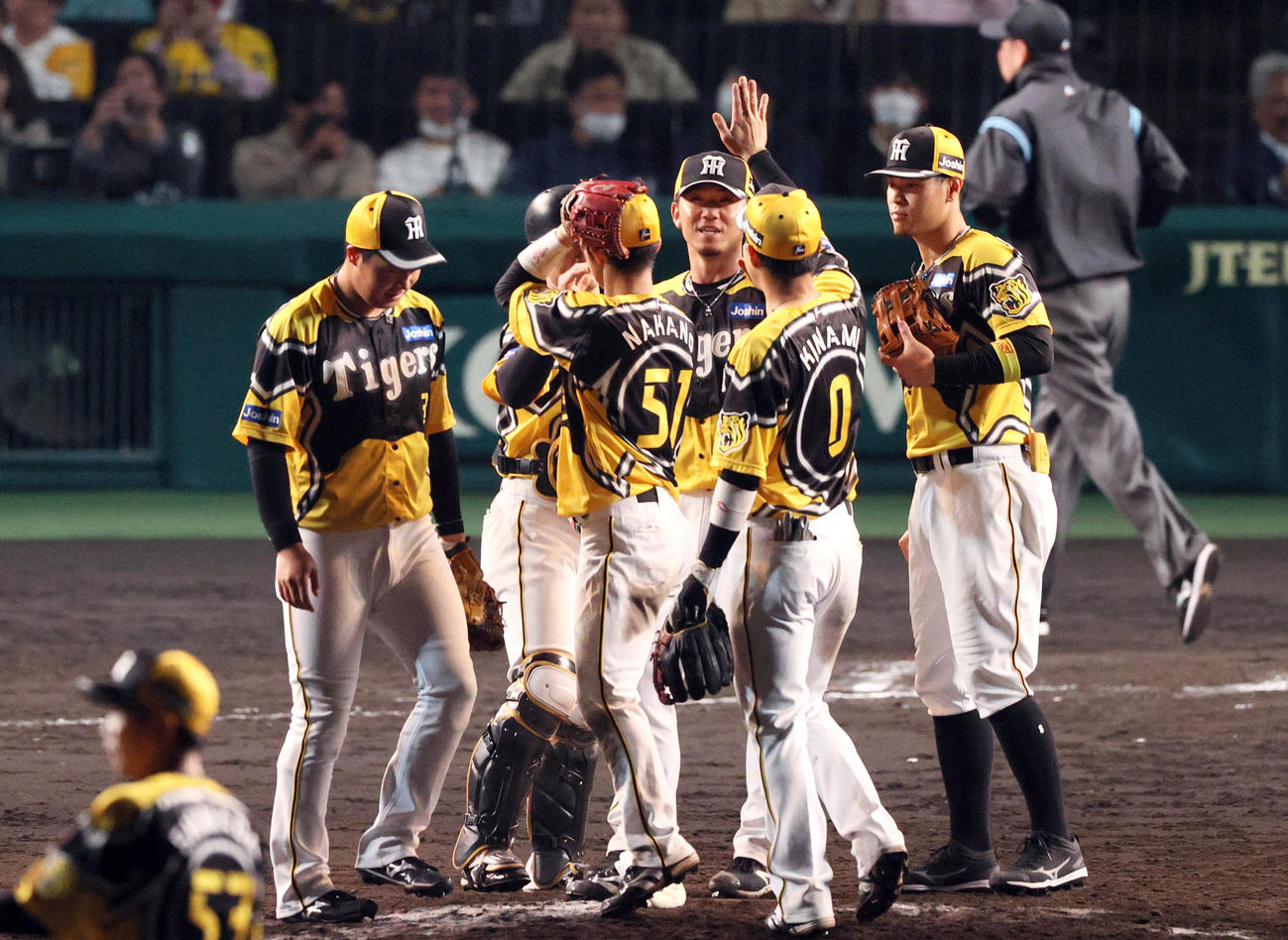 阪神対巨人　伊藤将（右から3人目）は巨人から完封勝利を挙げ、ナインとタッチを交わす（撮影・上山淳一）