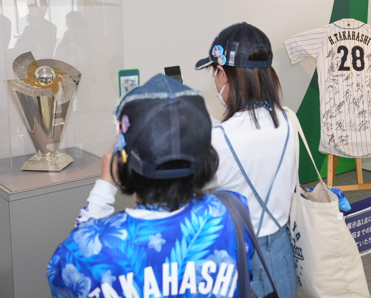 プロ野球中日対DeNA　試合前、特設展示場にお披露目されたWBC優勝トロフィーを写真に収めるファン（撮影・森本幸一）