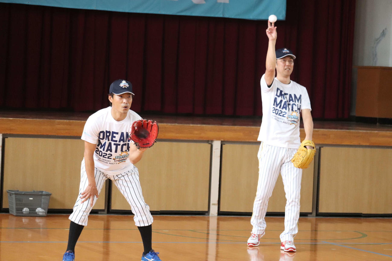 子どもらとキャッチボールする桧山進次郎氏（左）と金村暁氏