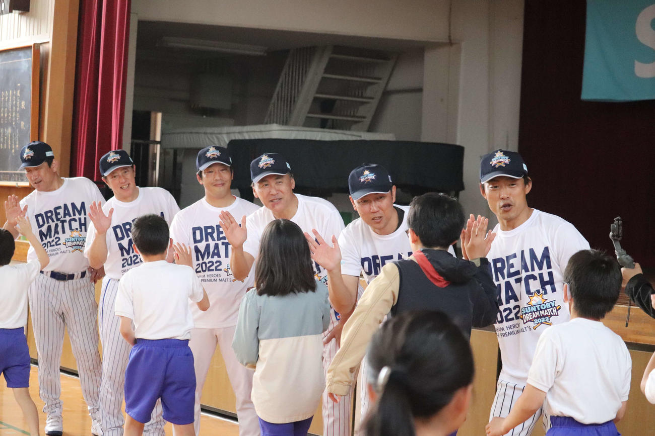子どもらとハイタッチを交わす講師陣。最右から桧山進次郎氏、金村暁氏、苫篠賢治氏、天谷宗一郎氏、高橋雅裕氏、久保文雄氏