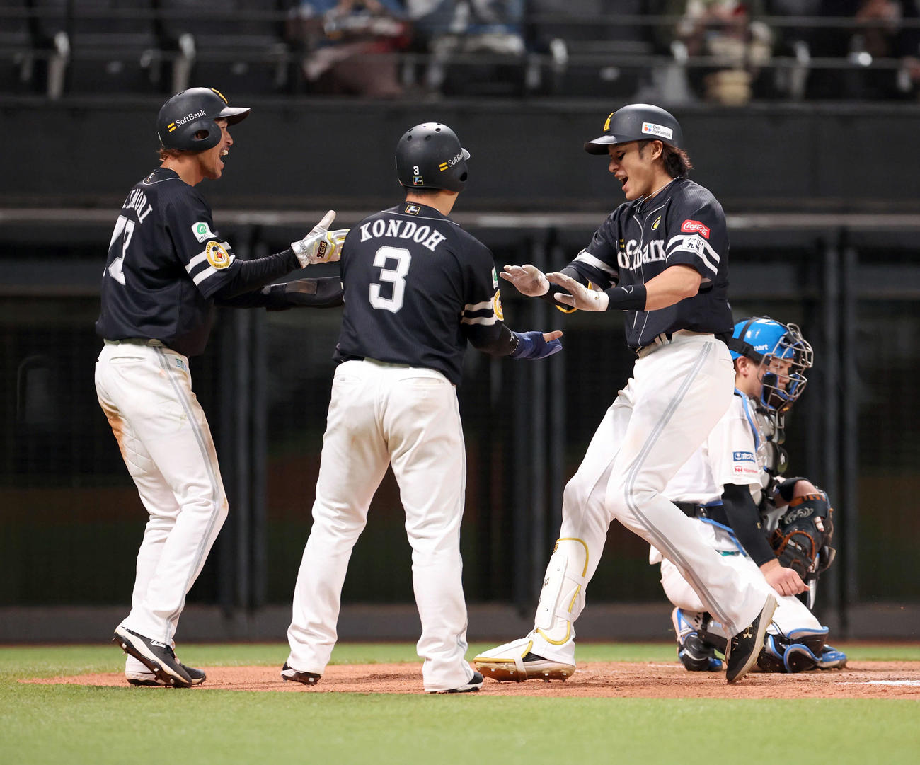 日本ハム対ソフトバンク　10回表ソフトバンク1死一、二塁、柳田（右）は勝ち越し3点本塁打を放ち、三森（左）、近藤に迎えられる（撮影・佐藤翔太）