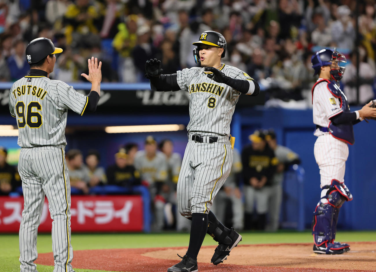 ヤクルト対阪神　5回表阪神無死、先制の本塁打を放ちタッチを交わす佐藤輝（中央）（撮影・足立雅史）