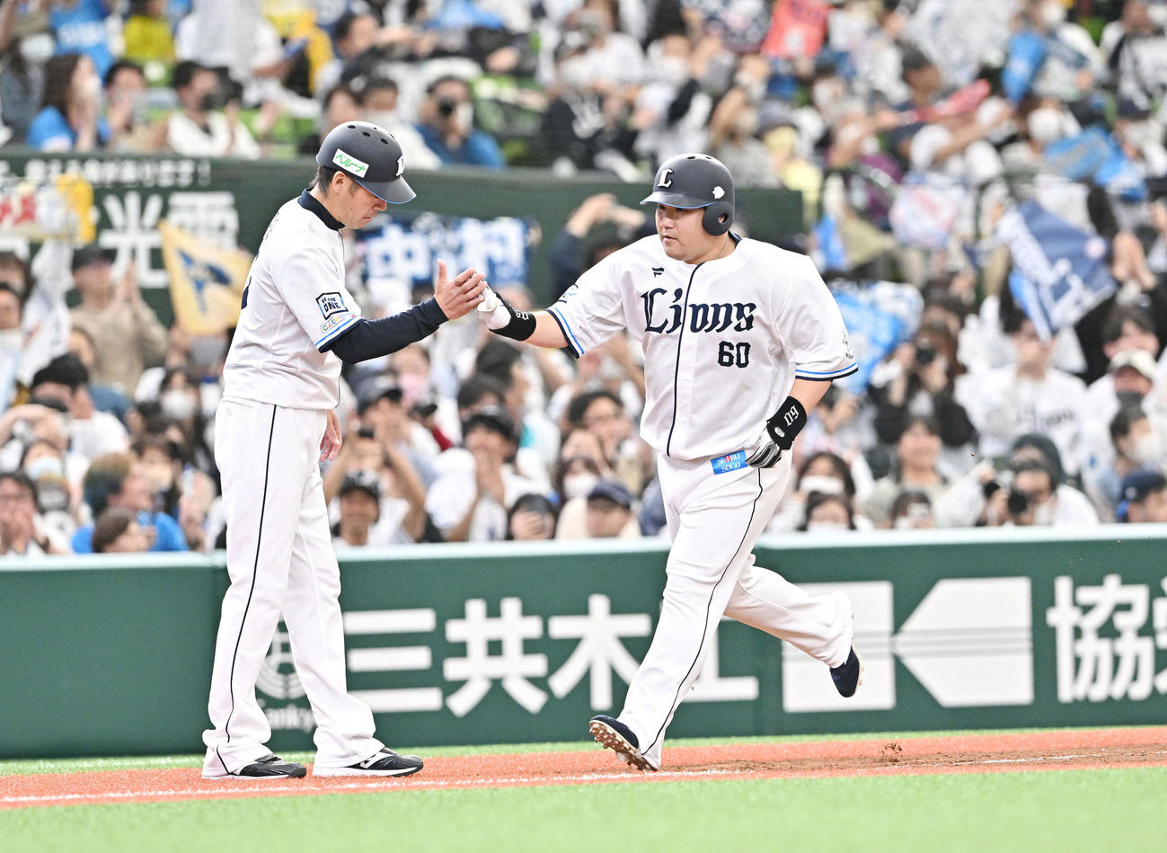 西武対楽天　5回裏西武2死三塁、左越え2点本塁打を放った中村（右）は黒田コーチとタッチを交わす（撮影・滝沢徹郎）