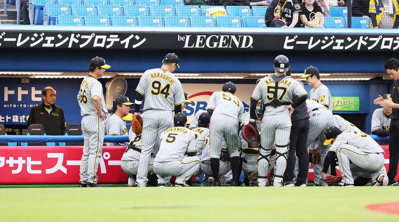 試合前、円陣の輪を見つめる阪神岡田監督（左端）（撮影・足立雅史）