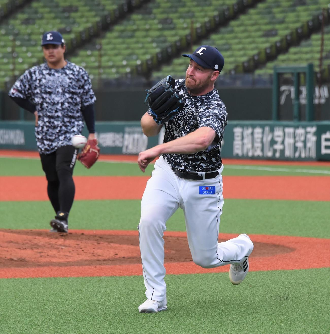 守備練習で軽快な動きを見せる西武ディートリック・エンス。左は松本（撮影・鈴木正章）