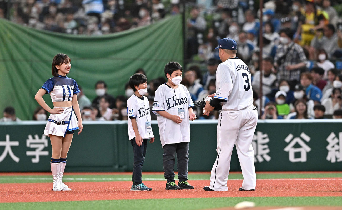 西武対日本ハム　守備に就く前に子どもたちにボールをプレゼントする西武一塁手山川（撮影・滝沢徹郎）