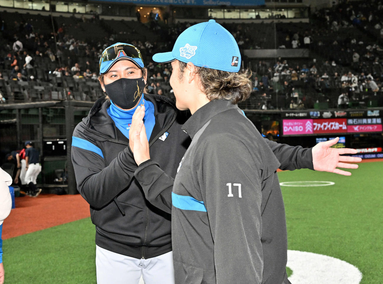 西武対日本ハム　試合後、今季初勝利の日本ハム伊藤（手前）とタッチを交わす新庄監督（撮影・滝沢徹郎）