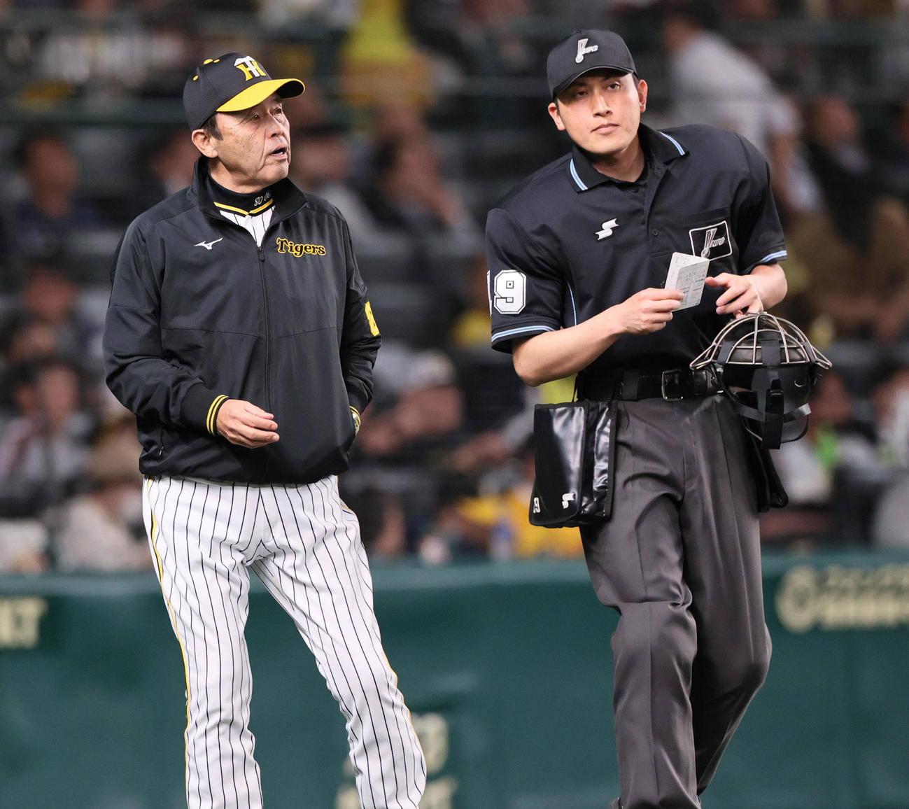 阪神対中日　8回裏終了後、阪神岡田監督（左）は球審に選手交代を告げる（撮影・上山淳一）