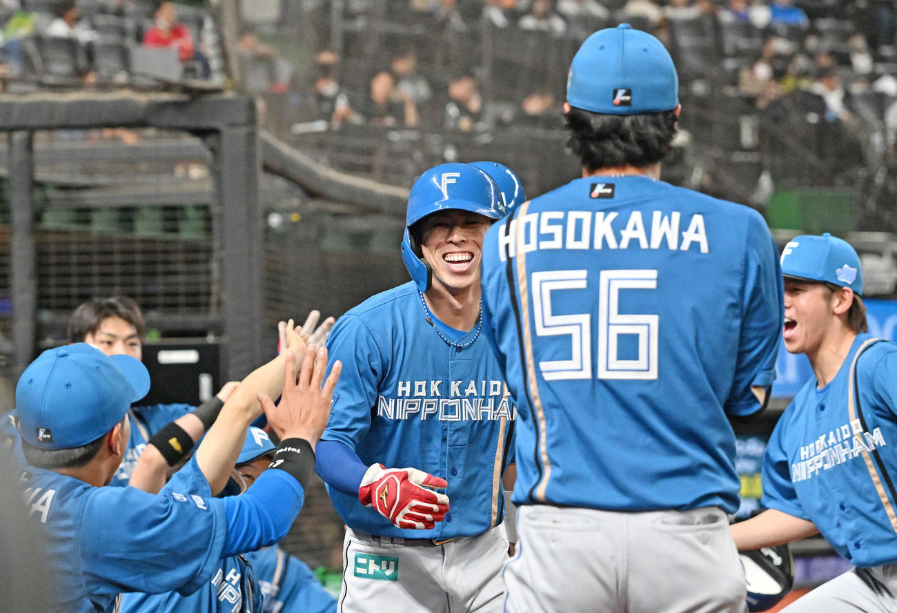 西武対日本ハム　3回表日本ハム無死三塁、江越のスクイズで生還した五十幡（中央）はチームメートの祝福に笑顔を見せる（撮影・滝沢徹郎）