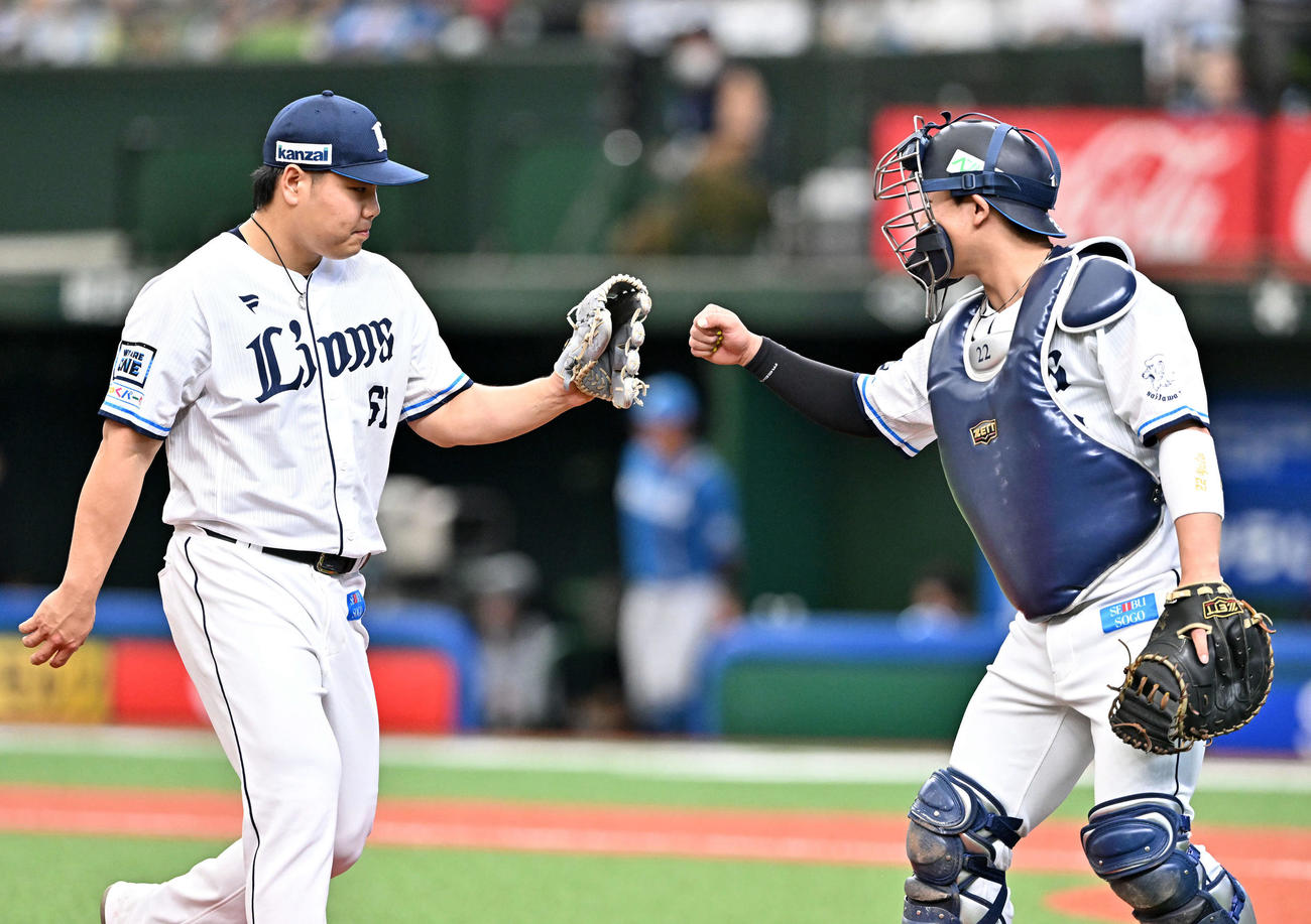 西武対日本ハム　2回表を投げ終えた西武先発の平良（左）は捕手古賀とタッチをかわす（撮影・滝沢徹郎）