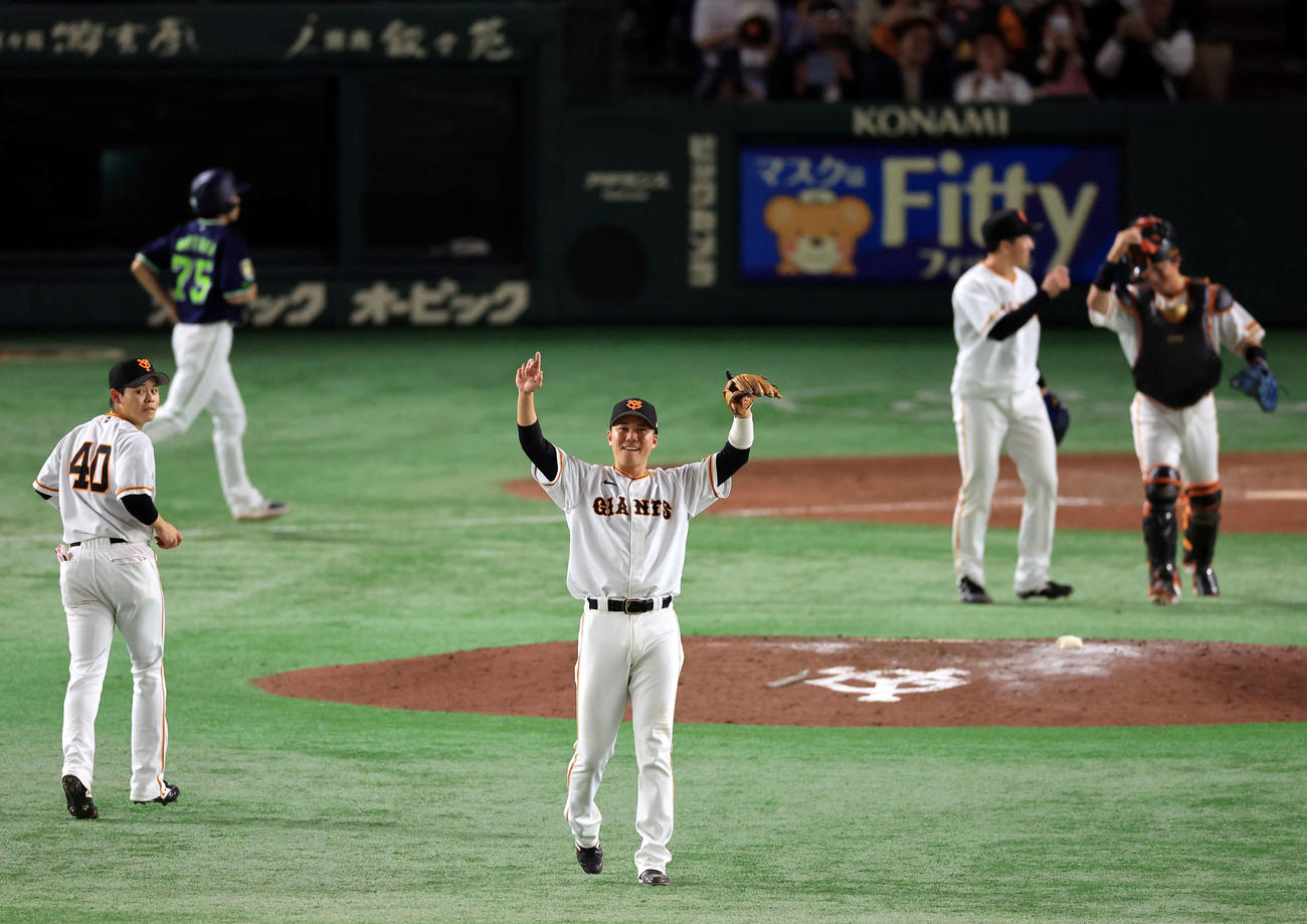 巨人対ヤクルト　9回表ヤクルトの攻撃を抑えて劇的勝利し、外野のブリンソンに向かって笑顔でバンザイする坂本（中央）（撮影・浅見桂子）