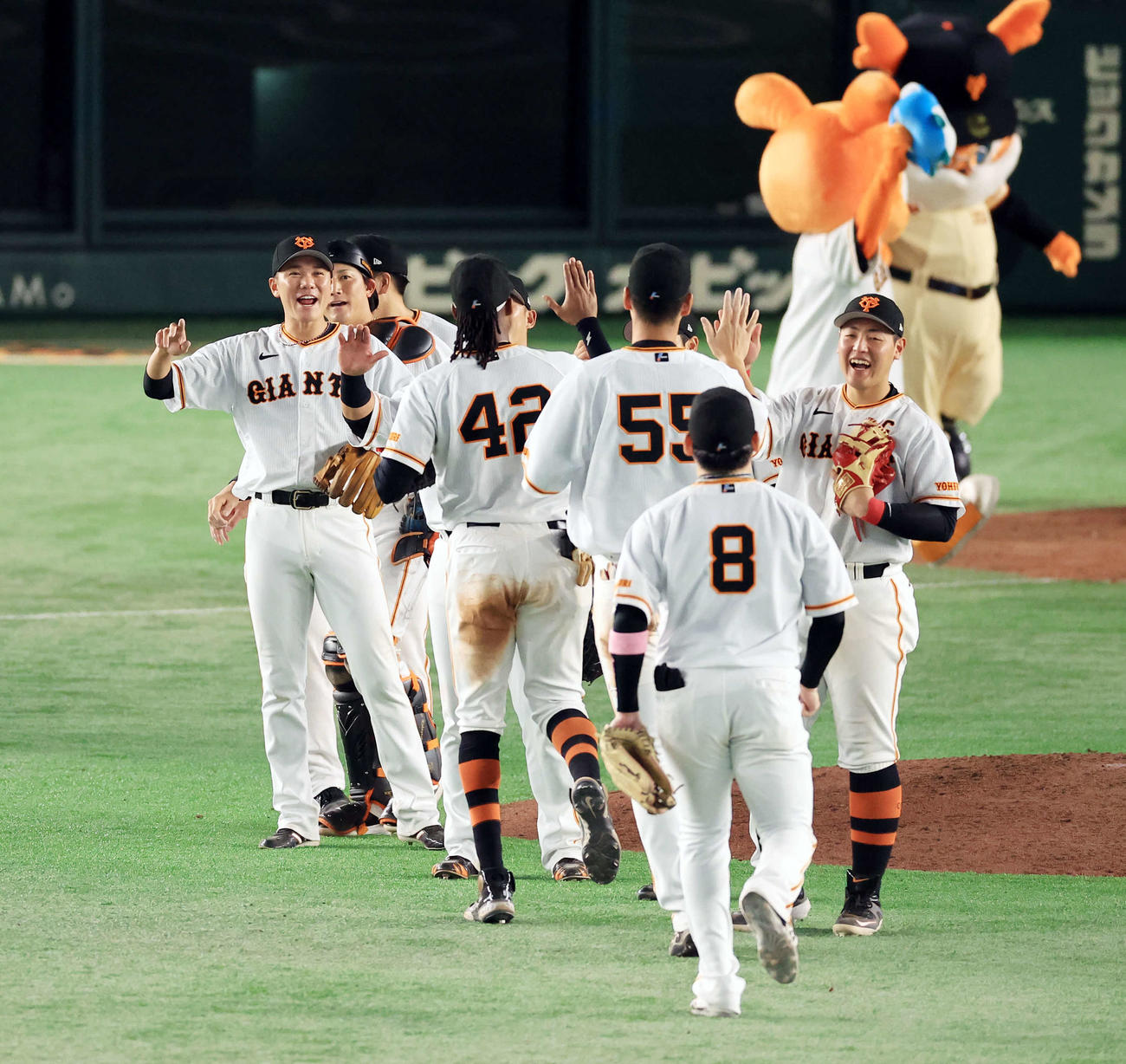 巨人対ヤクルト　9回表ヤクルトの攻撃を抑えて劇的勝利し、ブリンソン（中央）らと笑顔でハイタッチする坂本（左）ら巨人の選手たち（撮影・浅見桂子）