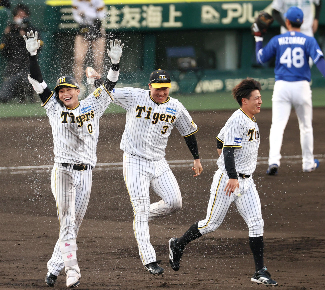 阪神対中日　9回裏阪神無死、木浪（左）は右前サヨナラ適時打を放ち、大山らからウオーターシャワーを浴びる（撮影・上山淳一）