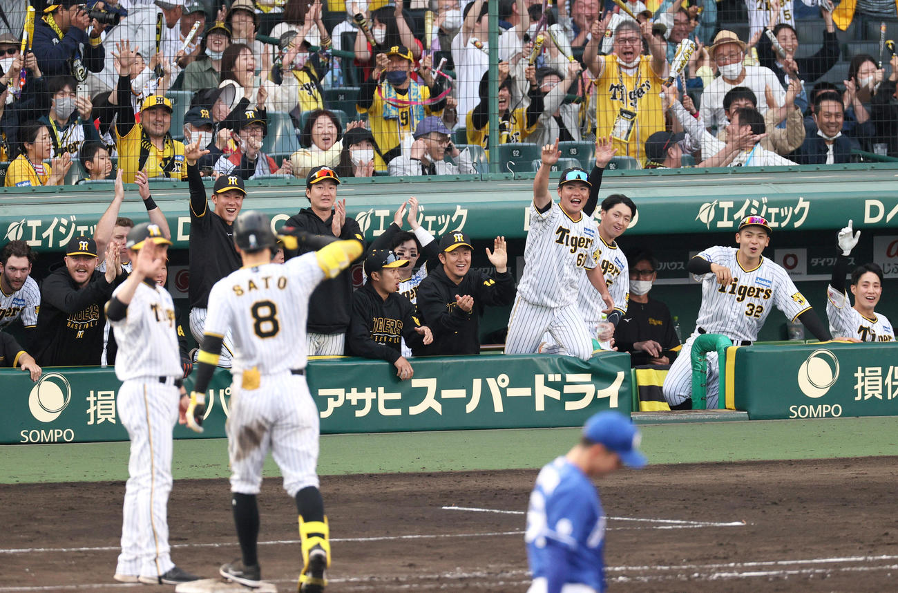 9回裏阪神無死二塁、佐藤輝（手前左から2人目）の打球を二塁手福永が後逸し、同点となり喜ぶ阪神ナイン（撮影・上山淳一）