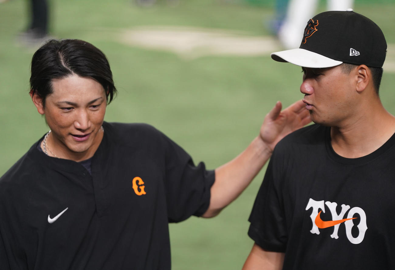 巨人対ヤクルト　試合前、小林（左）から声をかけられる支配下登録された三上（撮影・狩俣裕三）