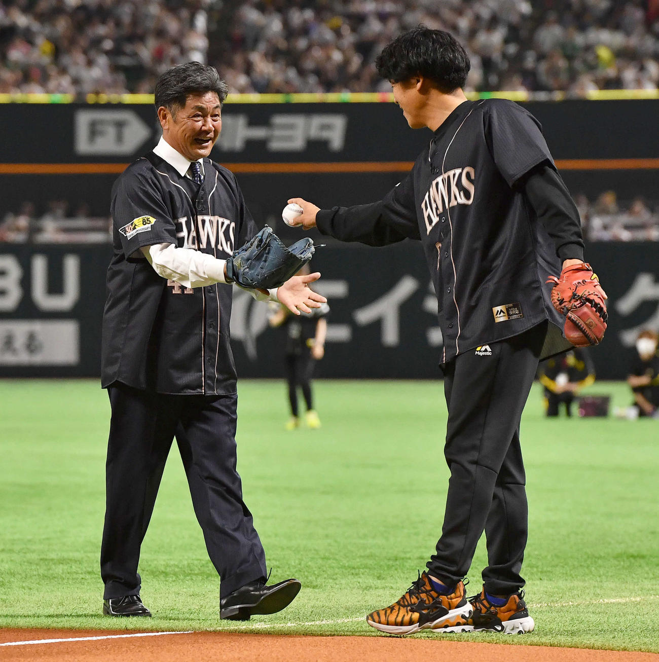 ソフトバンク対オリックス　「ダブルアニバーサリーデー」イベントのセレモニアルピッチでストレッチ投球し、バッテリーを組んだ城島アドバイザー（右）から笑顔でボールを受け取る工藤氏（撮影・岩下翔太）