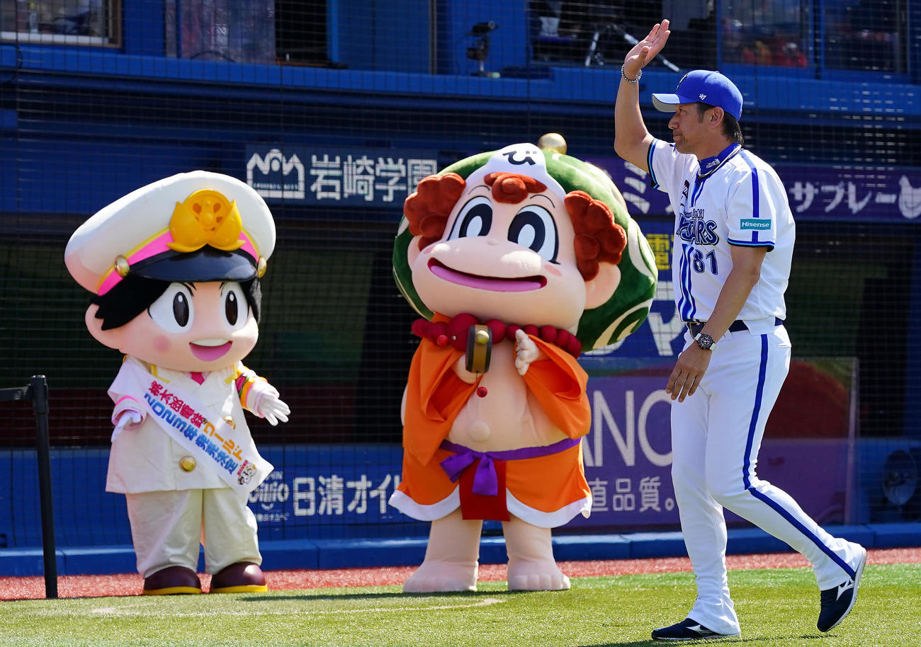 DeNA対広島　試合前、ゲーム桃太郎電鉄のキャラクターが見つめる中、スタンドに手を振るDeNA三浦監督（撮影・垰建太）