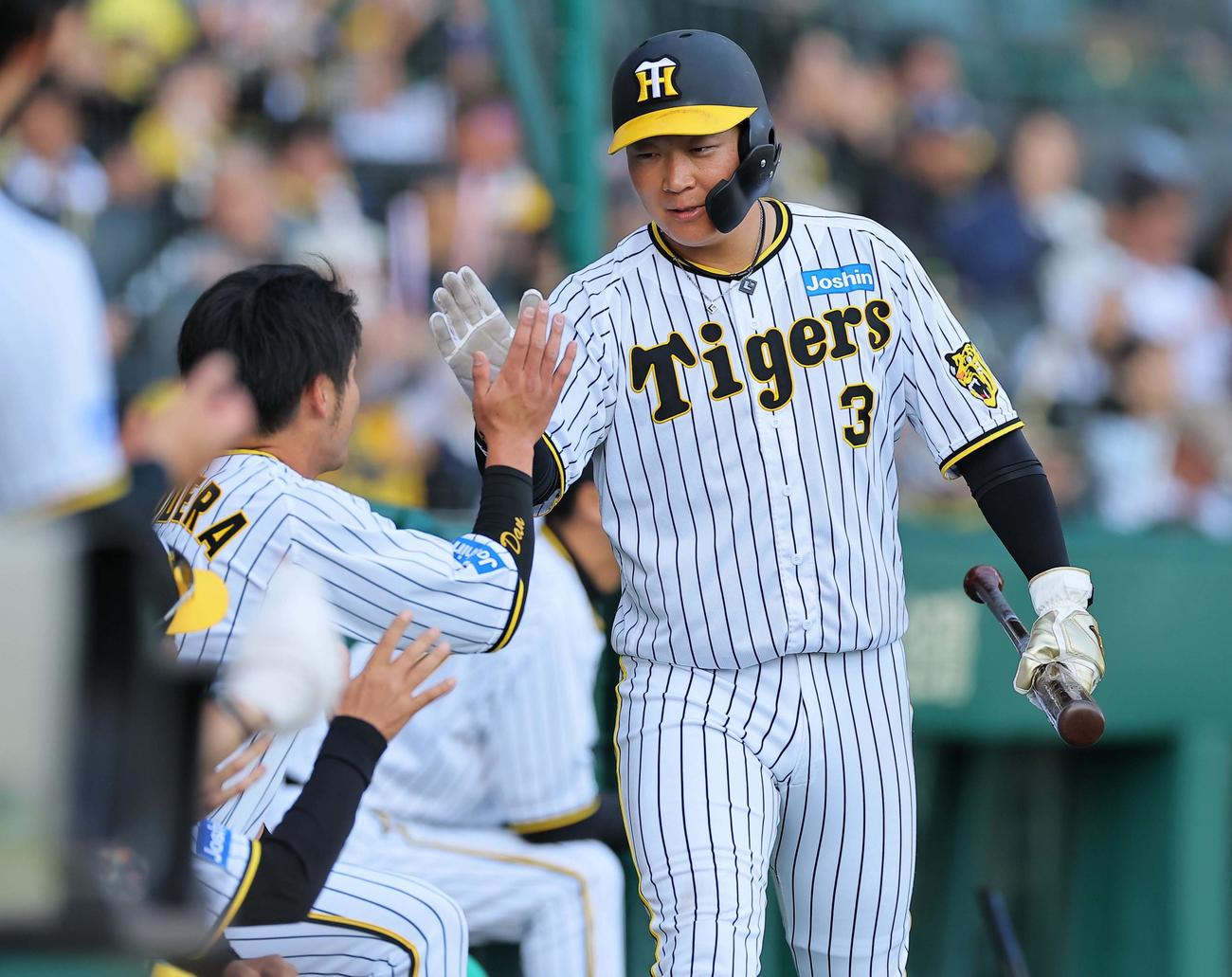 阪神対中日　7回裏阪神2死三塁、坂本誠志郎の中前適時打で生還しナインの出迎えを受ける大山（撮影・上田博志）