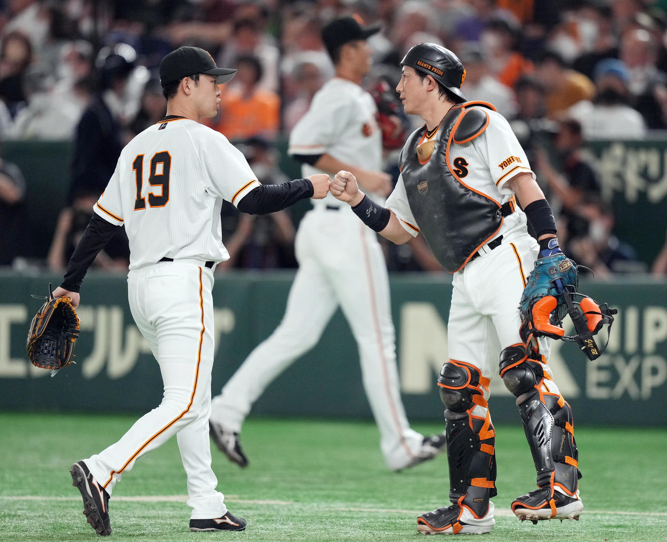 巨人対ヤクルト　3回表を抑え、タッチを交わす山崎伊（左）と小林（撮影・狩俣裕三）