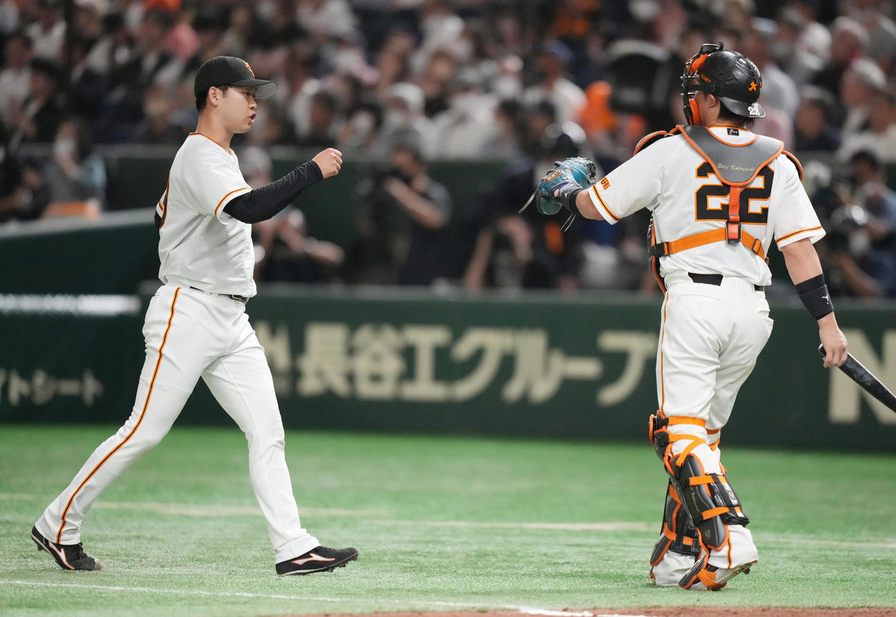 巨人対ヤクルト　6回表を抑え、小林（右）と気合の入った表情でタッチを交わす巨人先発の山崎伊（撮影・狩俣裕三）
