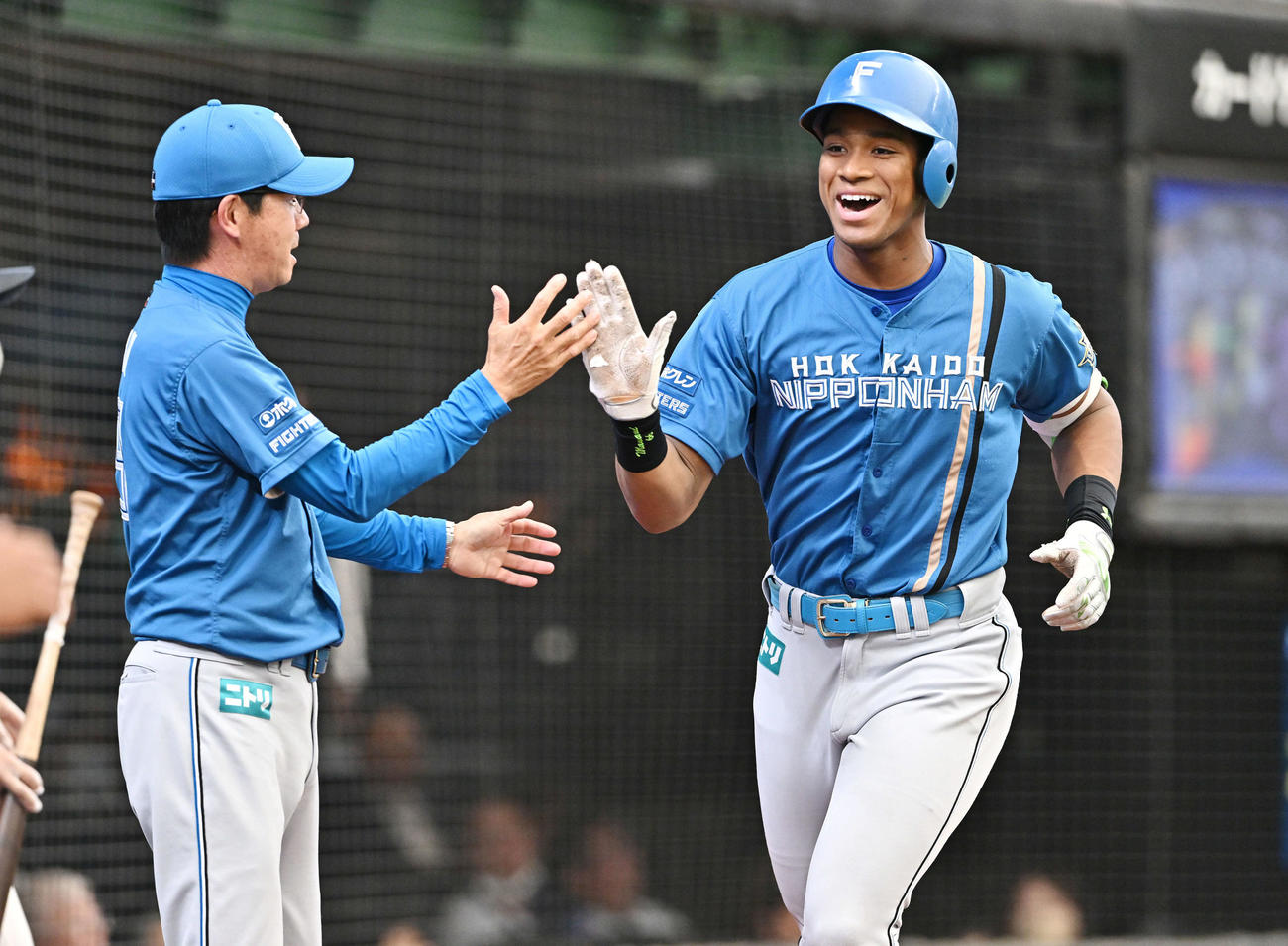 西武対日本ハム　7回表日本ハム1死、先制のソロ本塁打を放った万波（右）は生還し八木打撃コーチとタッチをかわす（撮影・滝沢徹郎）
