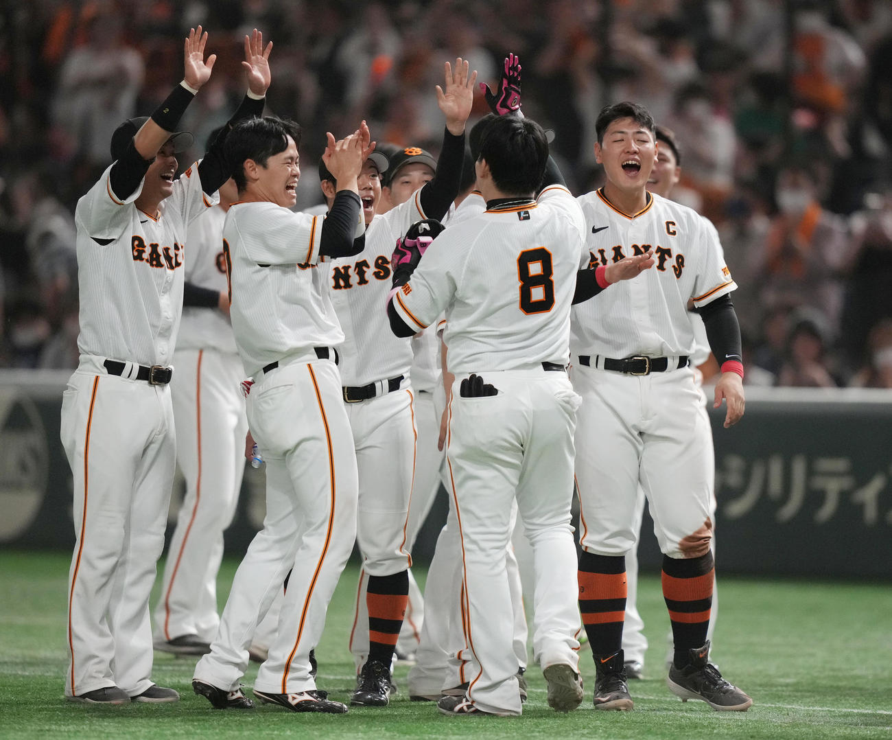 巨人対ヤクルト　9回裏巨人2死、サヨナラソロ本塁打を放った丸（手前）を迎える岡本和（右）らチームメートたち（撮影・狩俣裕三）