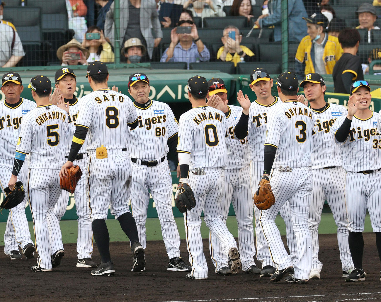 阪神対中日　中日に勝利し、ベンチ前でナインとタッチする岡田監督（左から5人目）ら（撮影・上山淳一）