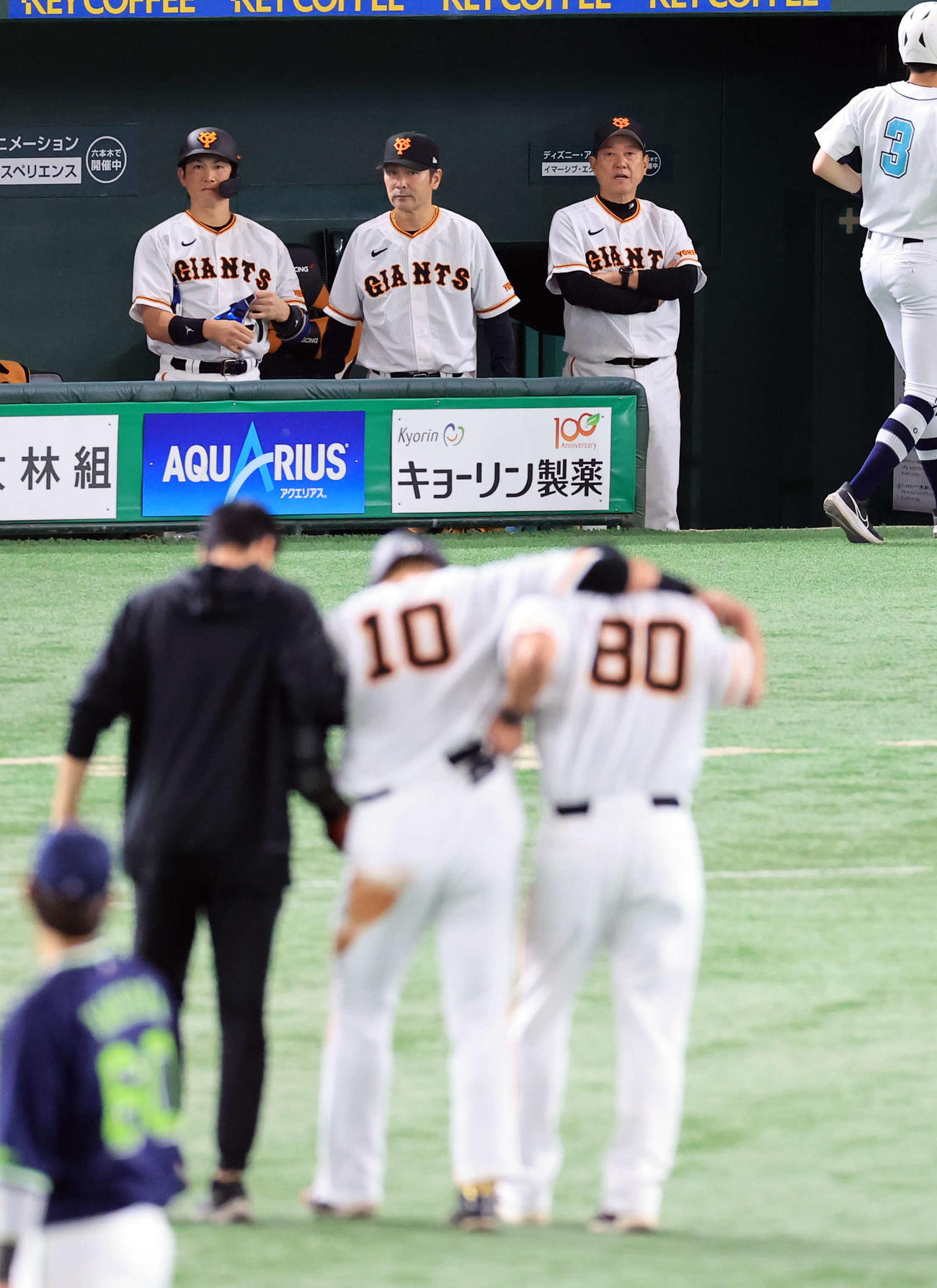 巨人対ヤクルト　2回裏巨人1死、中田翔（手前中央）がは左二塁打で走塁中に足を痛め、コーチ陣に担がれて引き揚げるのを心配そうに見つめる原監督（右奥）（撮影・浅見桂子）