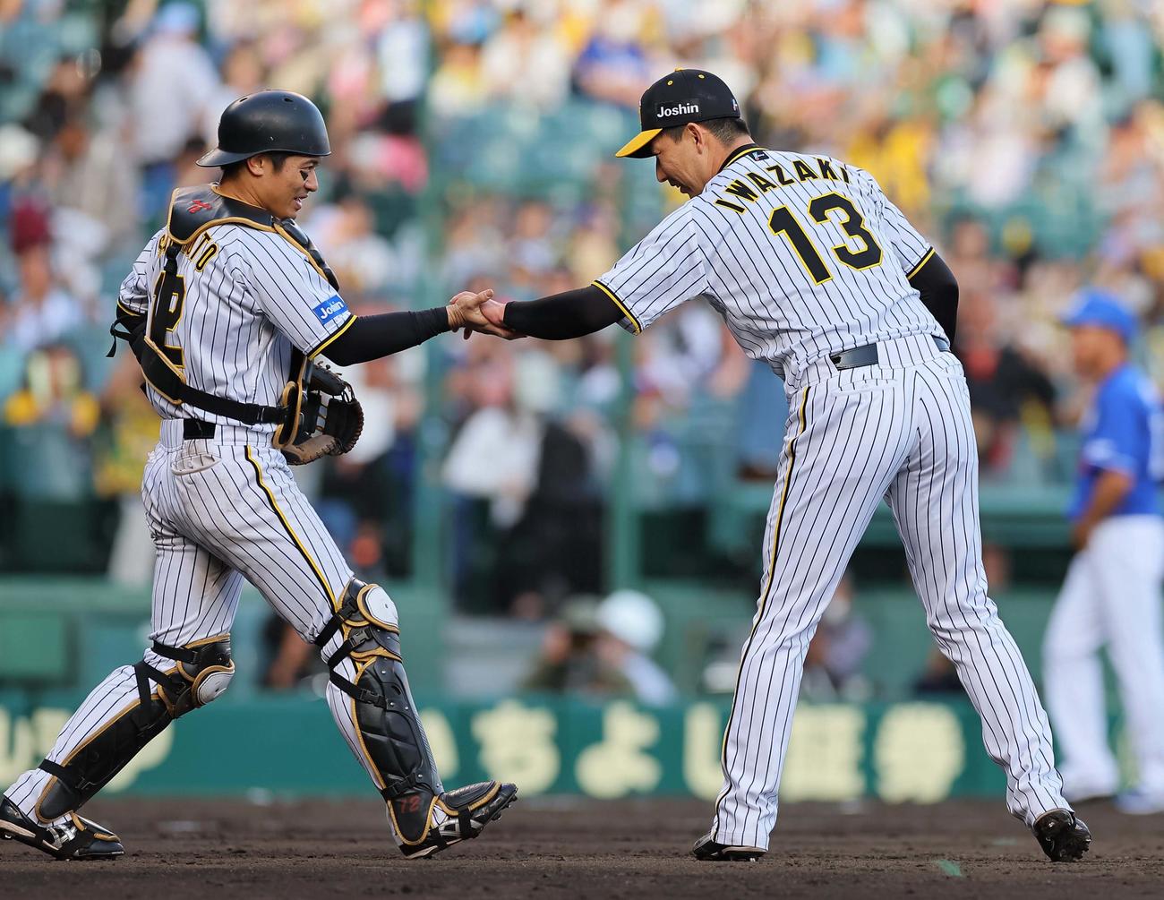 阪神対中日　今季初セーブをあげた岩崎（右）は坂本とタッチして喜び合う（撮影・上田博志）