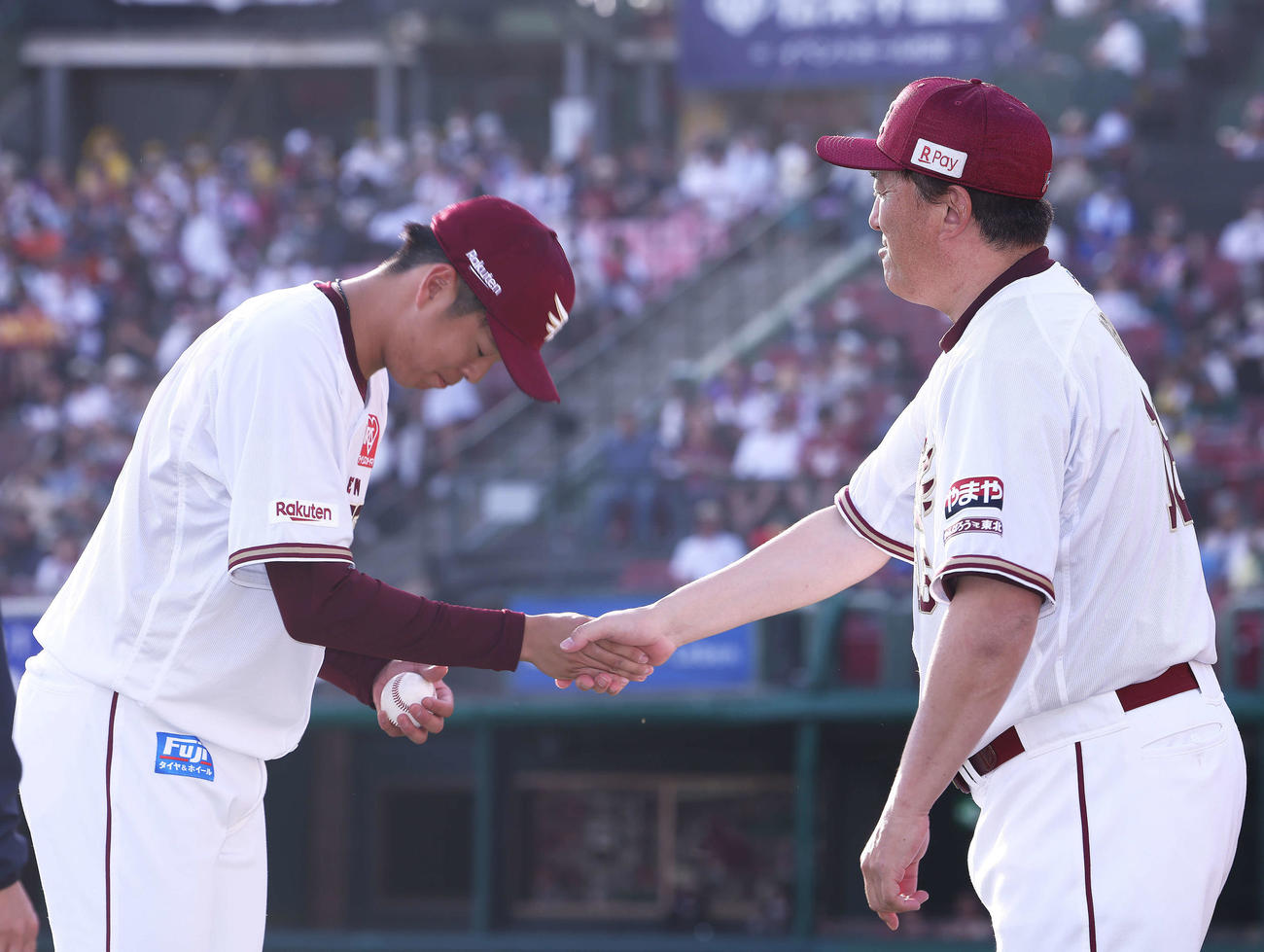 楽天対ロッテ　ロッテに勝利し、プロ初勝利を飾り石井監督（右）と握手を交わす松井友（撮影・河田真司）