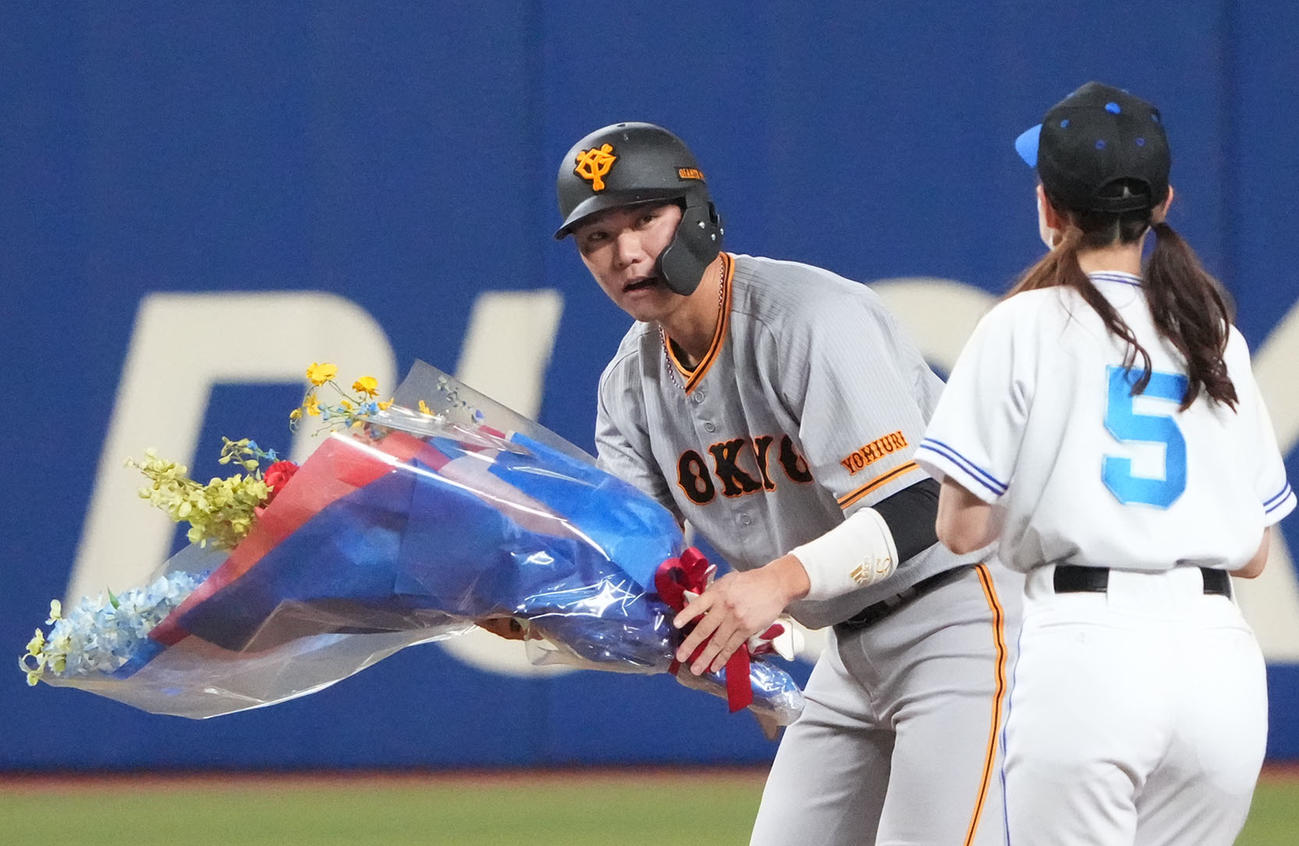 プロ野球中日対巨人　7回表巨人2死、中越え二塁打を放ち通算3500塁打を達成し花束を受け取る坂本（撮影・森本幸一）