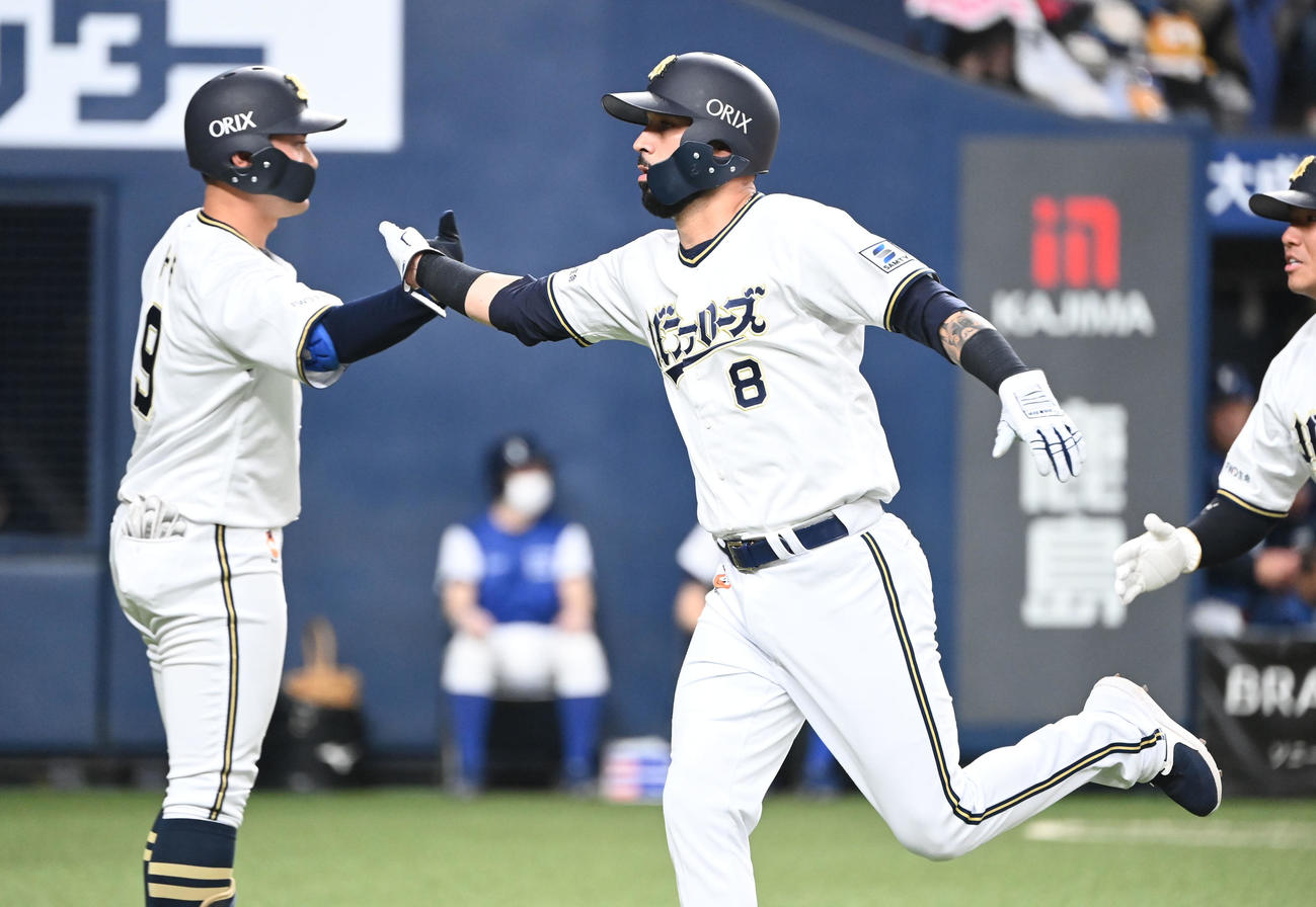 オリックス対西武　4回裏オリックス無死二、三塁、シュウィンデルの適時打で生還し野口（左）とタッチを交わすゴンザレス（撮影・和賀正仁）
