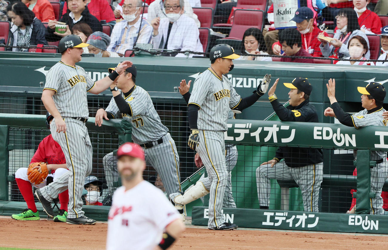 広島対阪神　1回表阪神2死一塁、岡田監督は左越え2点本塁打を放った大山（中央）を笑顔で出迎える。左は生還した一塁走者ノイジー（撮影・加藤哉）