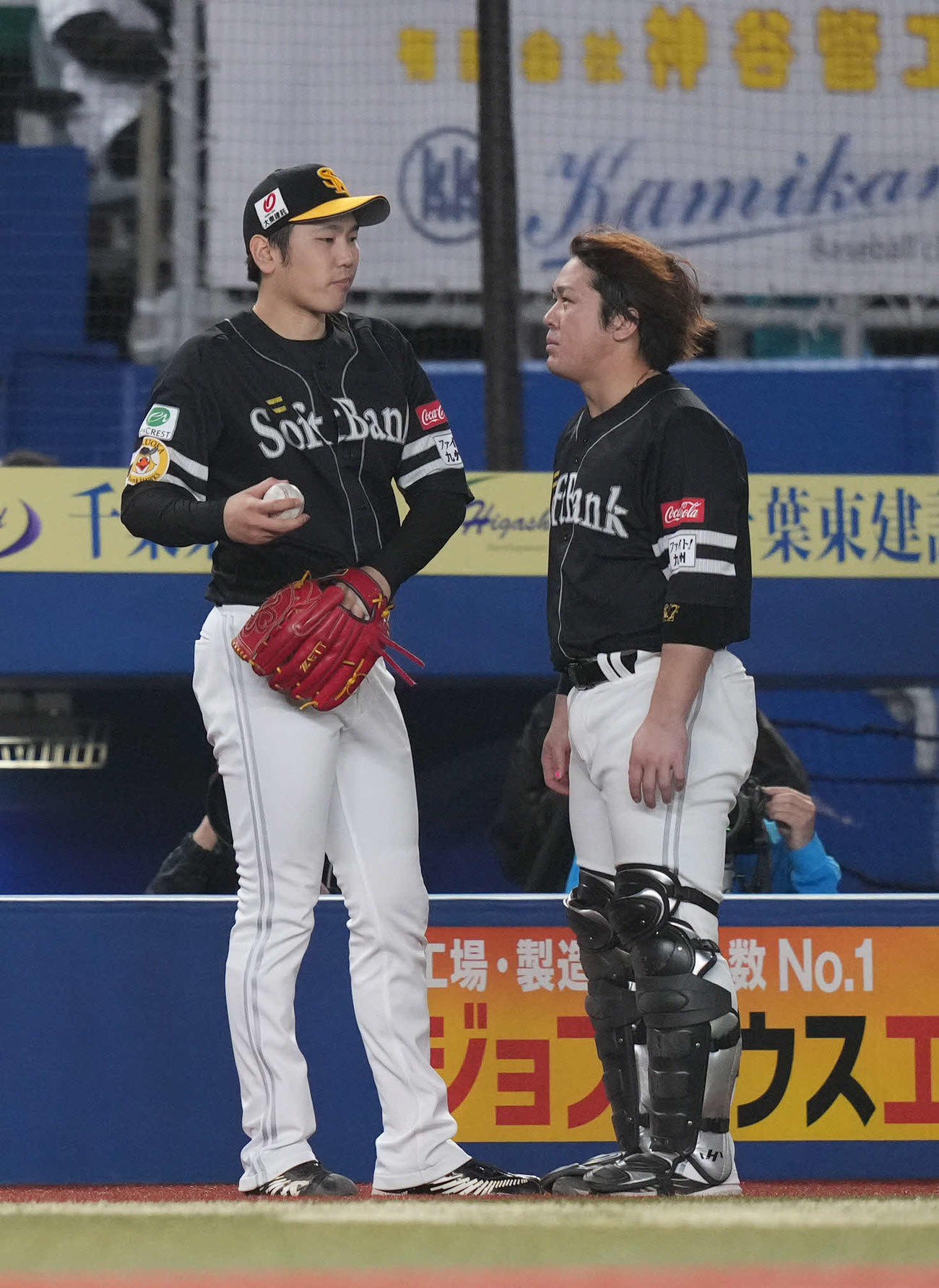 ロッテ対ソフトバンク　7回裏、ベンチ前で話をする石川（左）と甲斐（撮影・狩俣裕三）