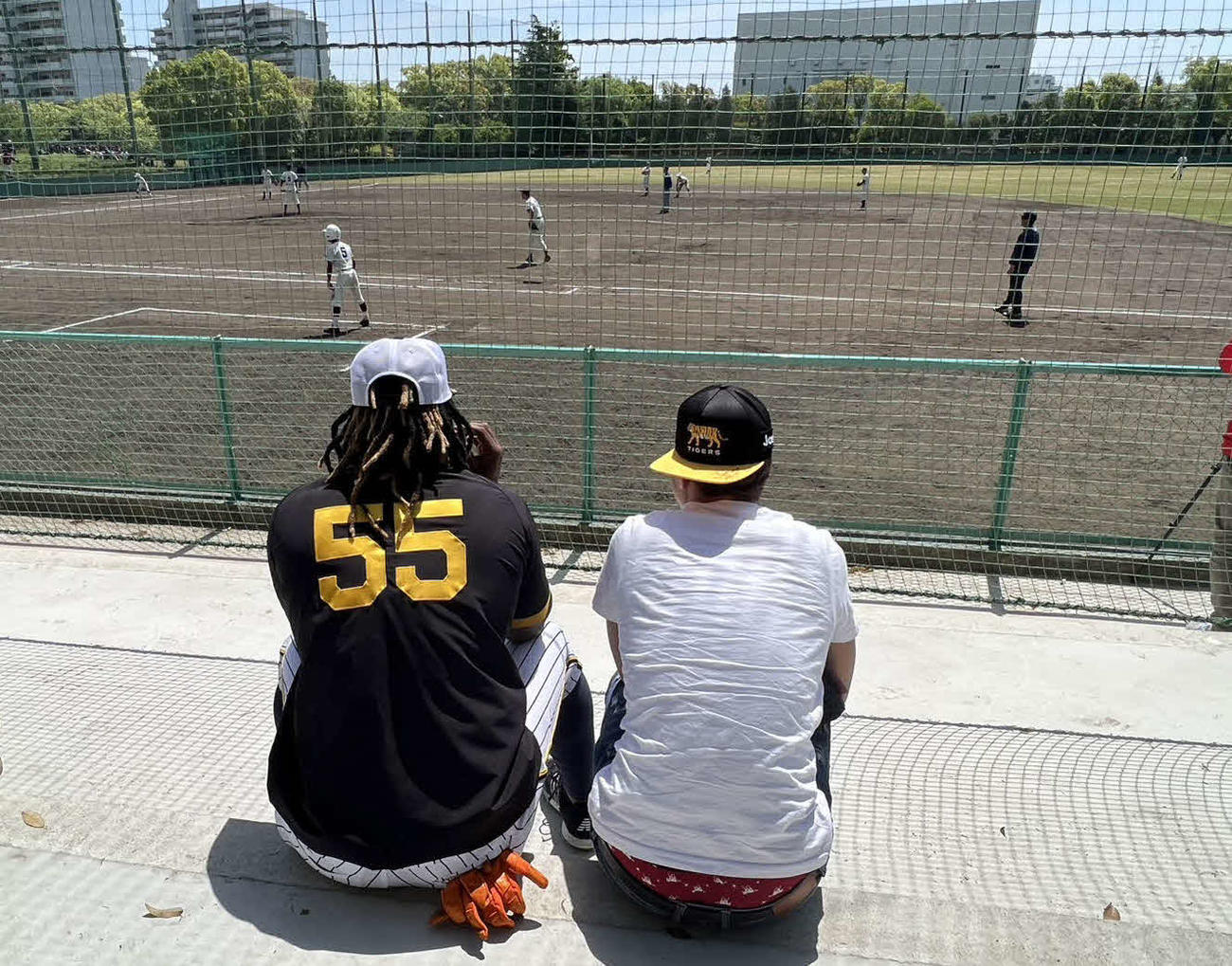 中学生がプレーしている試合を観戦する新助っ人ミエセス（左）と親戚