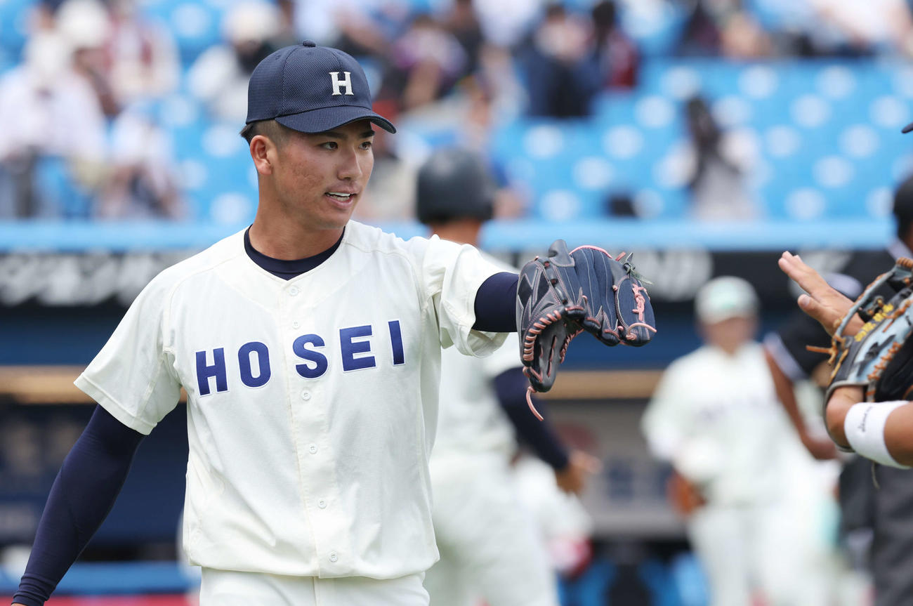 早大対法大　3回表を無失点に抑え、チームメートとタッチを交わす法大先発の篠木（撮影・宮地輝）