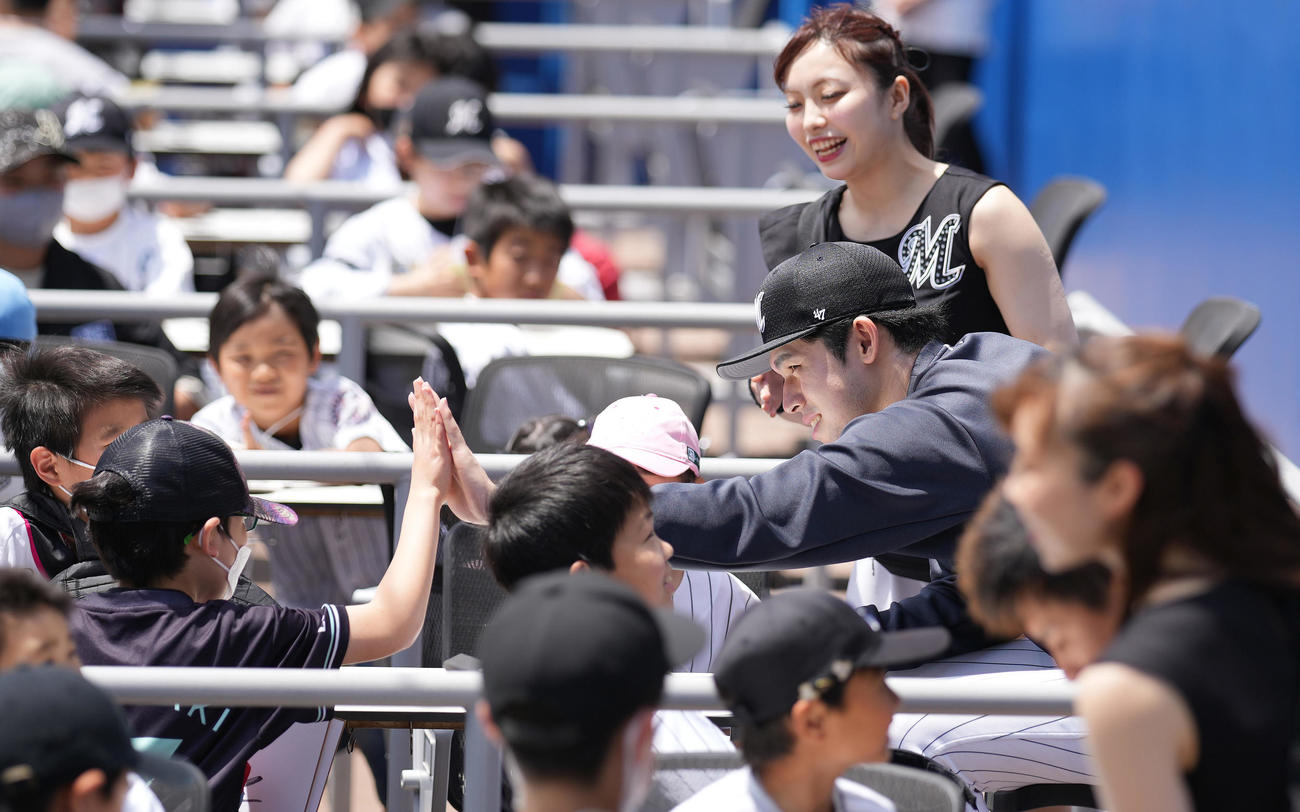 ロッテ対ソフトバンク　試合前、子供とハイタッチするロッテ佐々木朗（撮影・鈴木みどり）