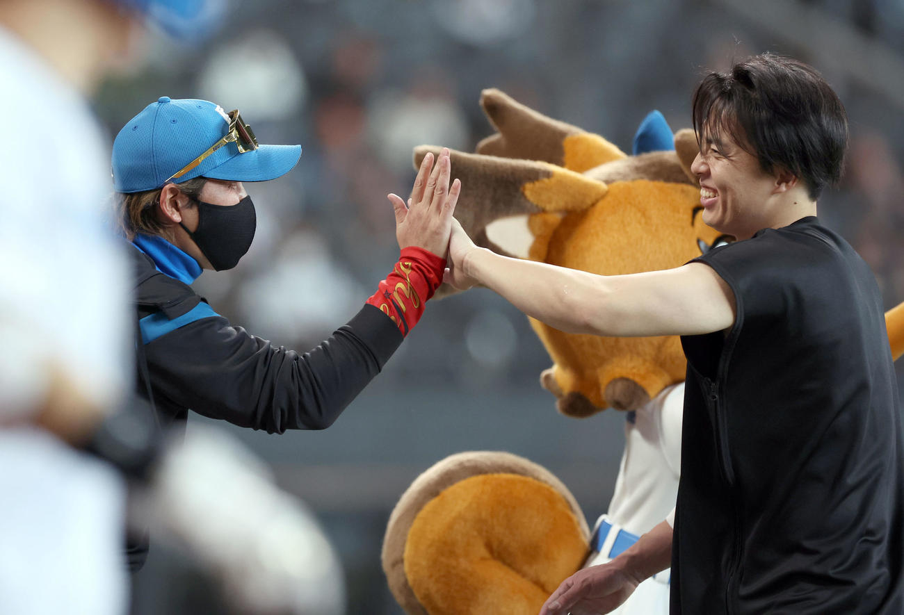 日本ハム対楽天　サヨナラ勝利を決め日本ハム新庄監督（左）はプロ初勝利を挙げた田中正と笑顔でタッチを交わす（撮影・佐藤翔太）