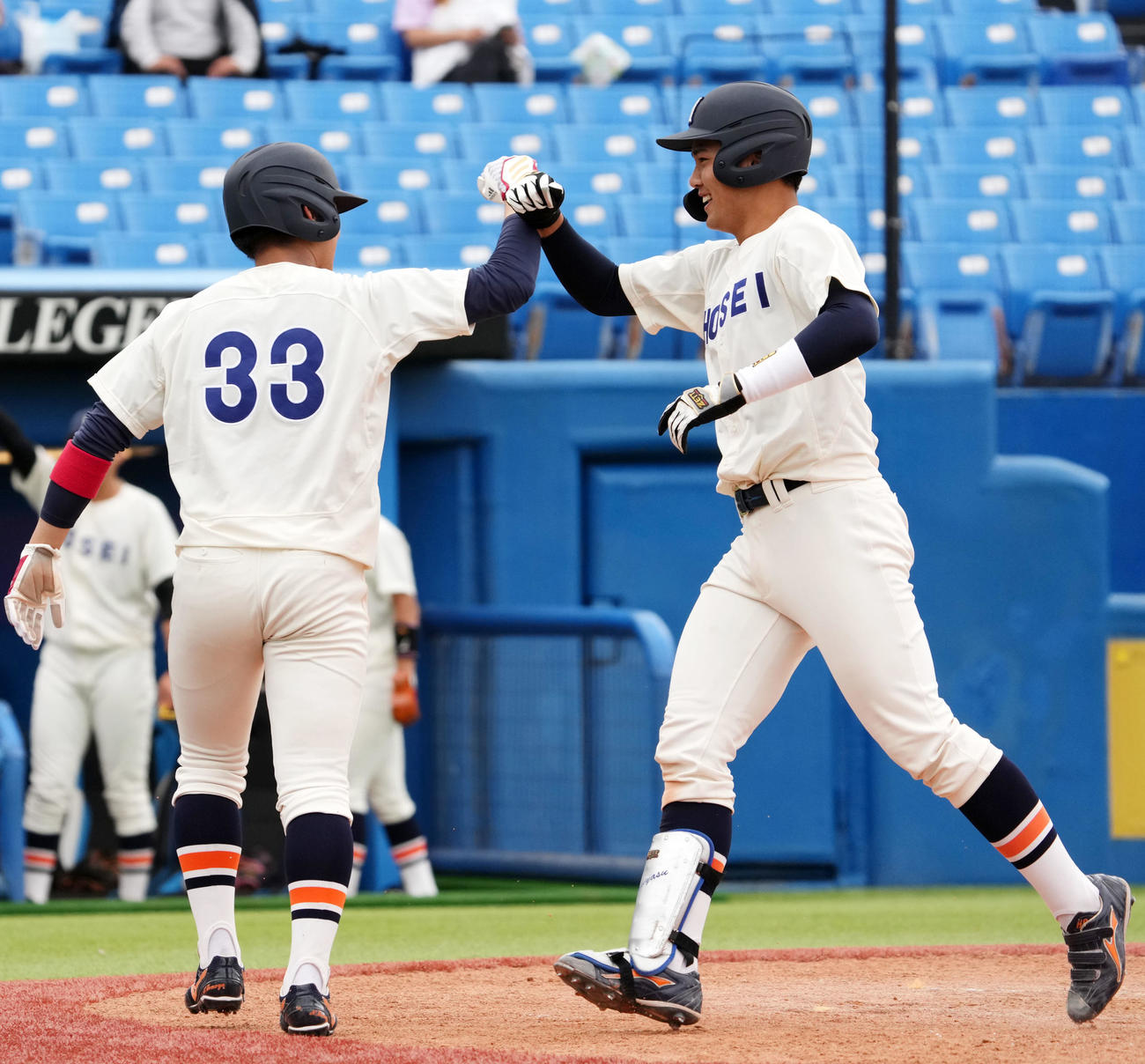 法大対早大　5回表法大2死一塁、右越え2点本塁打を放ちタッチを交わす吉安（右）（撮影・横山健太）