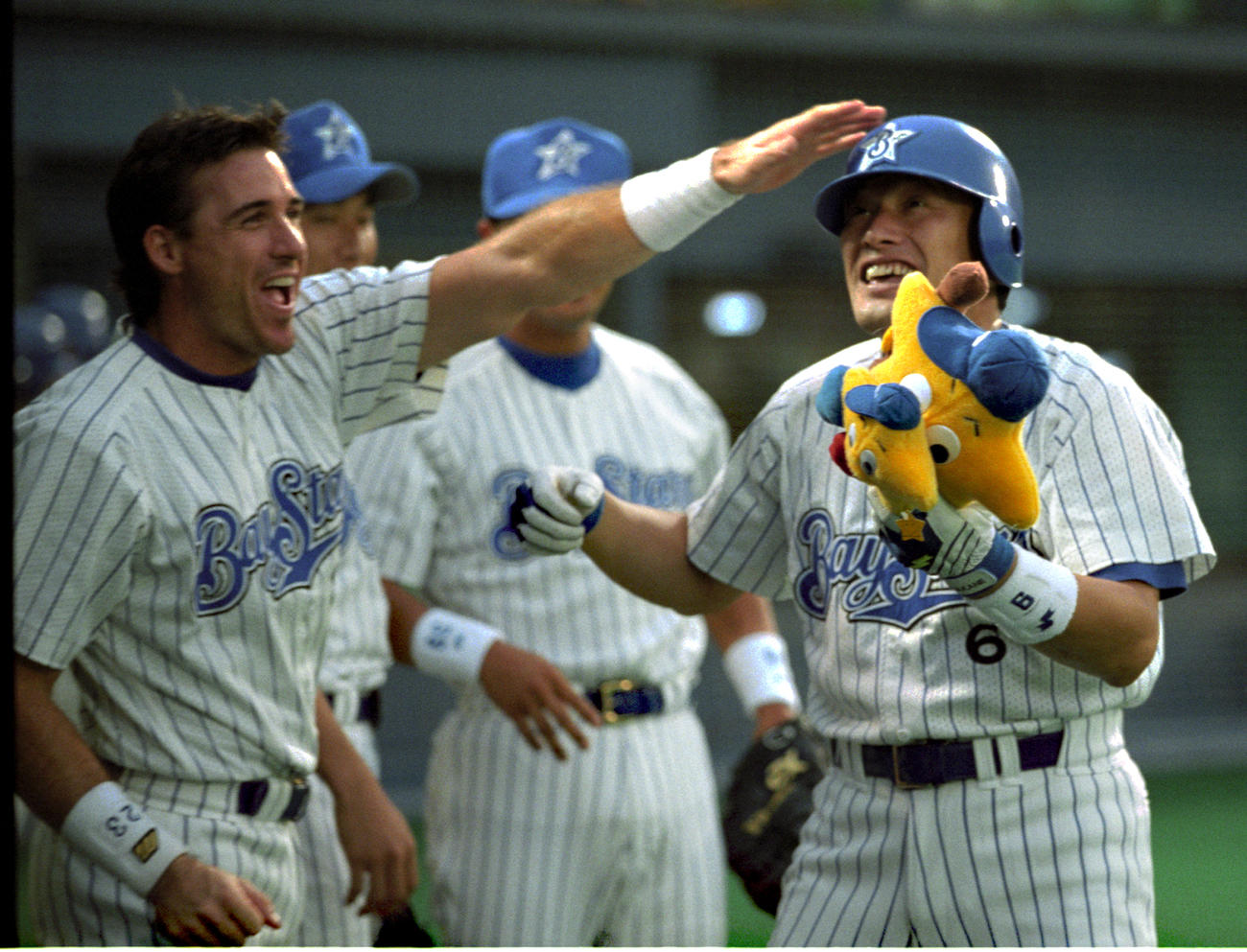 1998年6月、本塁打を放って生還した中根仁の頭をたたくロバート・ローズ