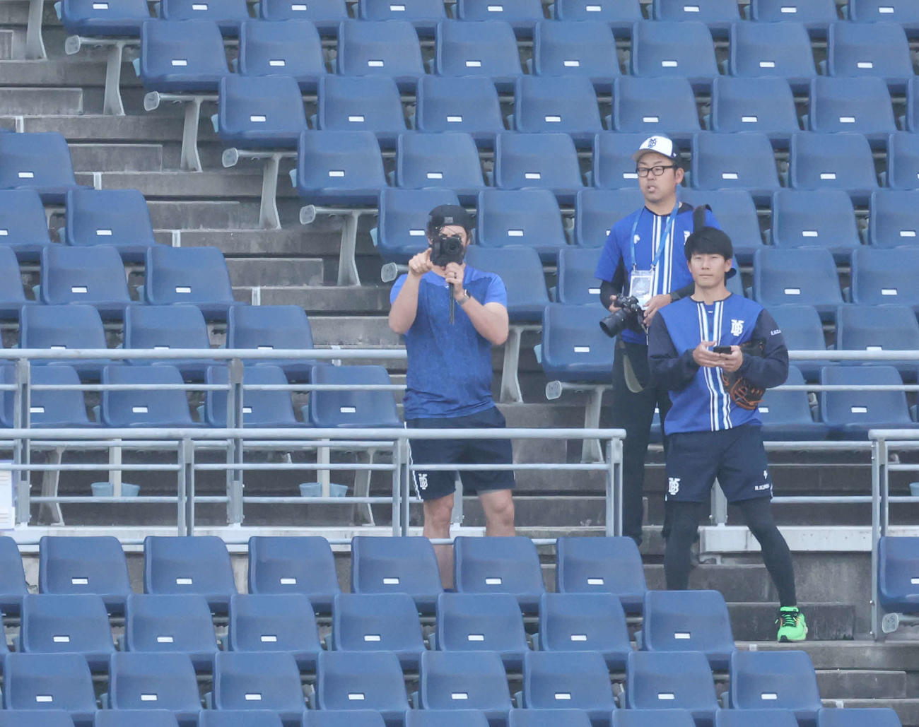DeNA対巨人　試合前、スタンドで撮影するDeNAバウアー（左）（撮影・宮地輝）