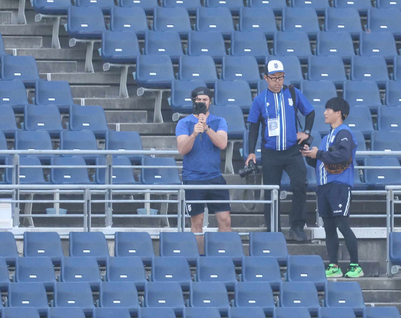 DeNA対巨人　試合前、スタンドで撮影するDeNAバウアー（左）（撮影・宮地輝）