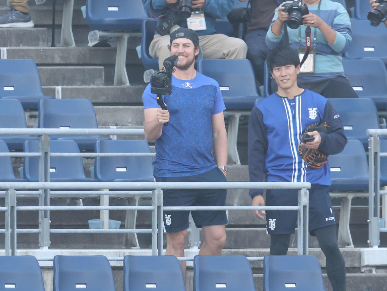 DeNA対巨人　試合前、スタンドで笑顔で撮影するDeNAバウアー（左）（撮影・宮地輝）