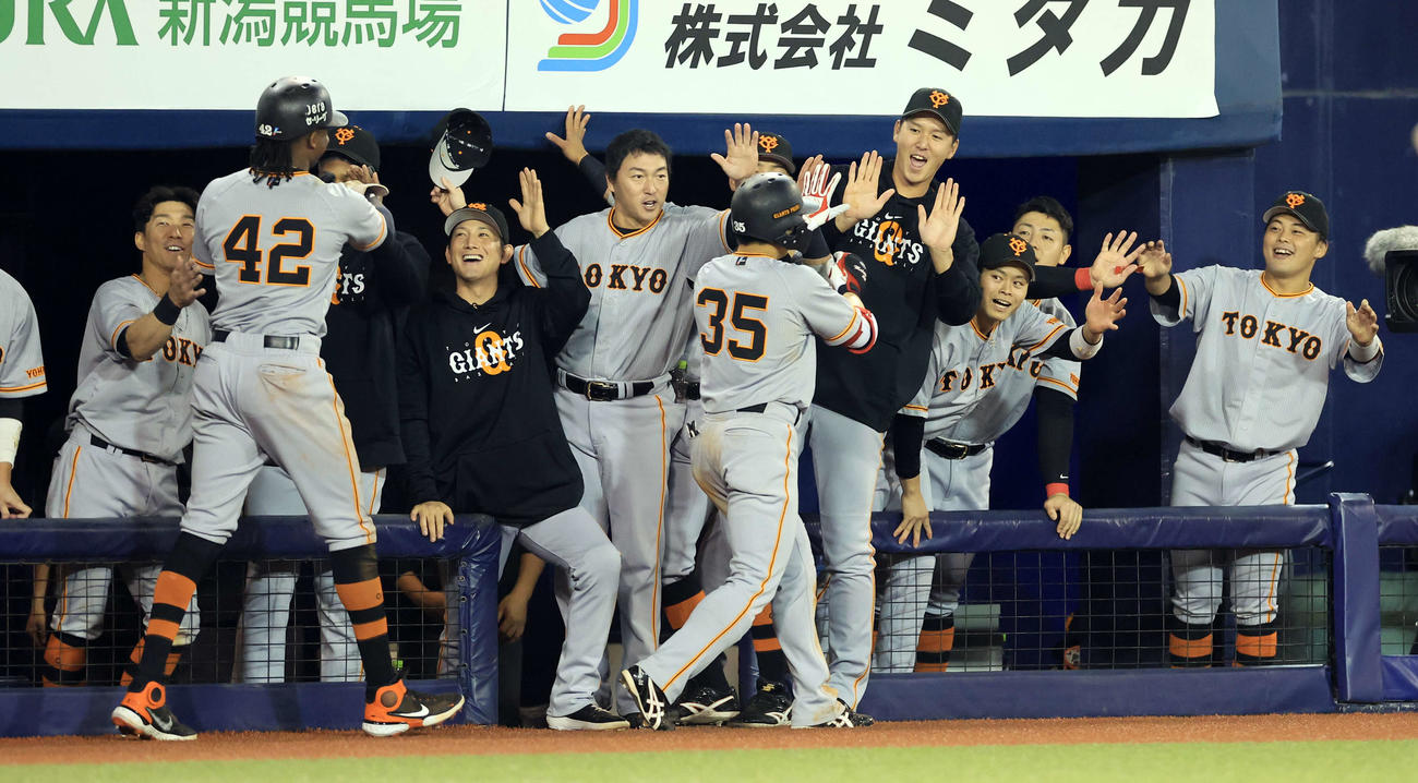 DeNA対巨人　6回表巨人1死一塁、門脇（中央）がプロ1号となる右越え2点本塁打を放ち、笑顔で迎える巨人の選手たち（撮影・浅見桂子）