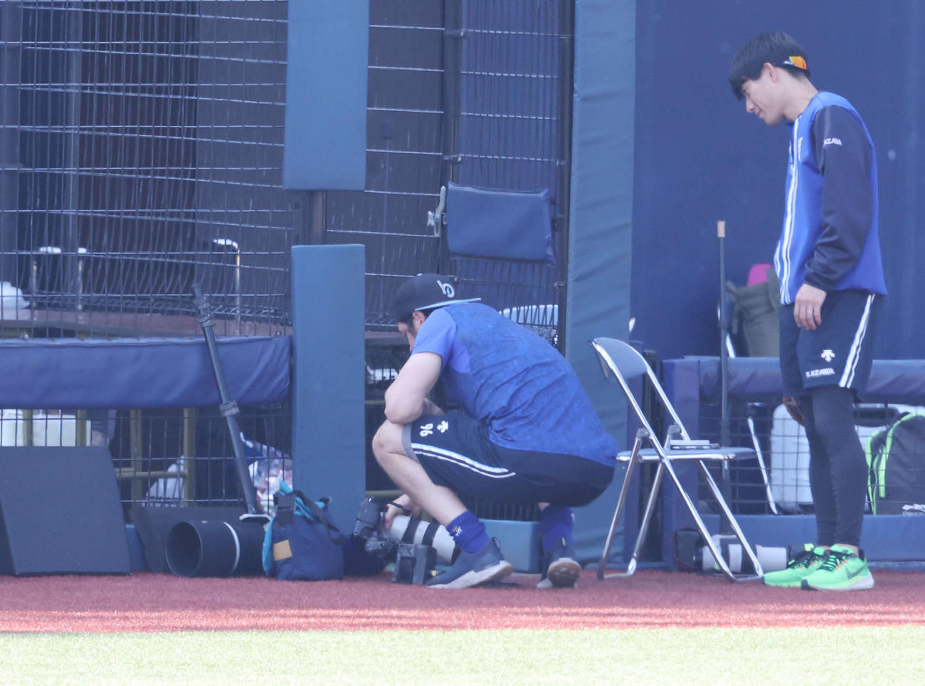 DeNA対巨人　試合前、カメラマンのカメラをチェックするDeNAバウアー（左）（撮影・宮地輝）