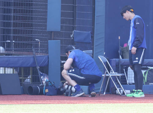 DeNA対巨人　試合前、カメラマンのカメラをチェックするDeNAバウアー（左）（撮影・宮地輝）