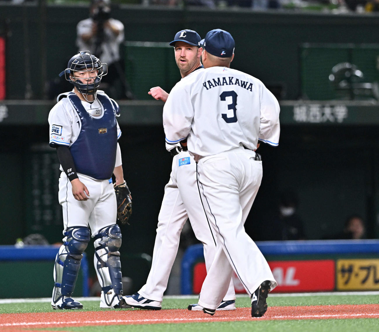 西武対ロッテ　2回表を投げ終えた西武先発のエンス（中央）は山川（右）とタッチをかわす。捕手古賀（撮影・滝沢徹郎）