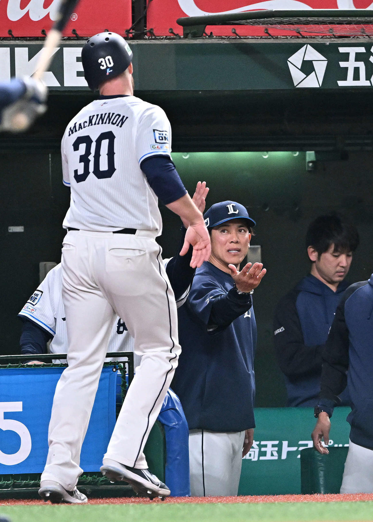 西武対ロッテ　5回裏西武無死一塁、山川の適時二塁打から生還したマキノン（手前）を迎える松井監督（撮影・滝沢徹郎）