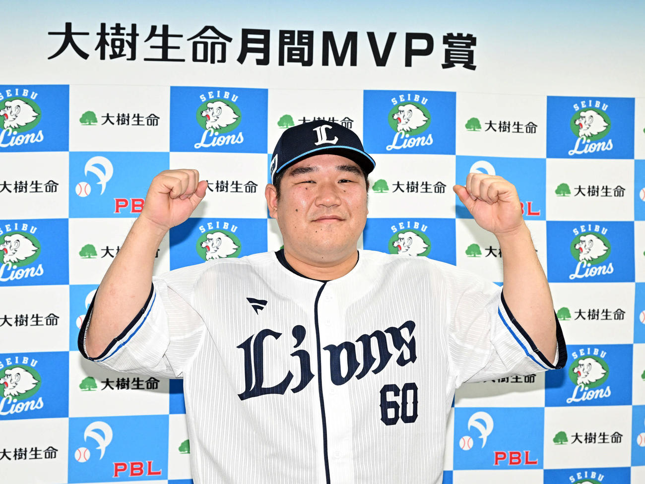 月間MVPを受賞した西武中村は記念撮影でガッツポーズする（撮影・滝沢徹郎）