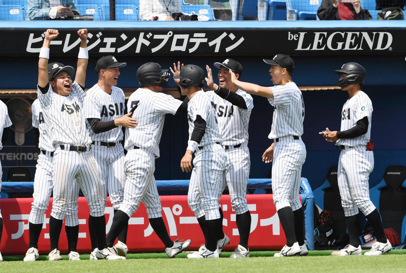 亜大対駒大　6回表亜大1死一、三塁、公文のスクイズで三塁走者古山が生還しナインの出迎えを受ける（撮影・柴田隆二）
